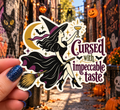 Cursed With Impeccable Taste sticker, shown in use